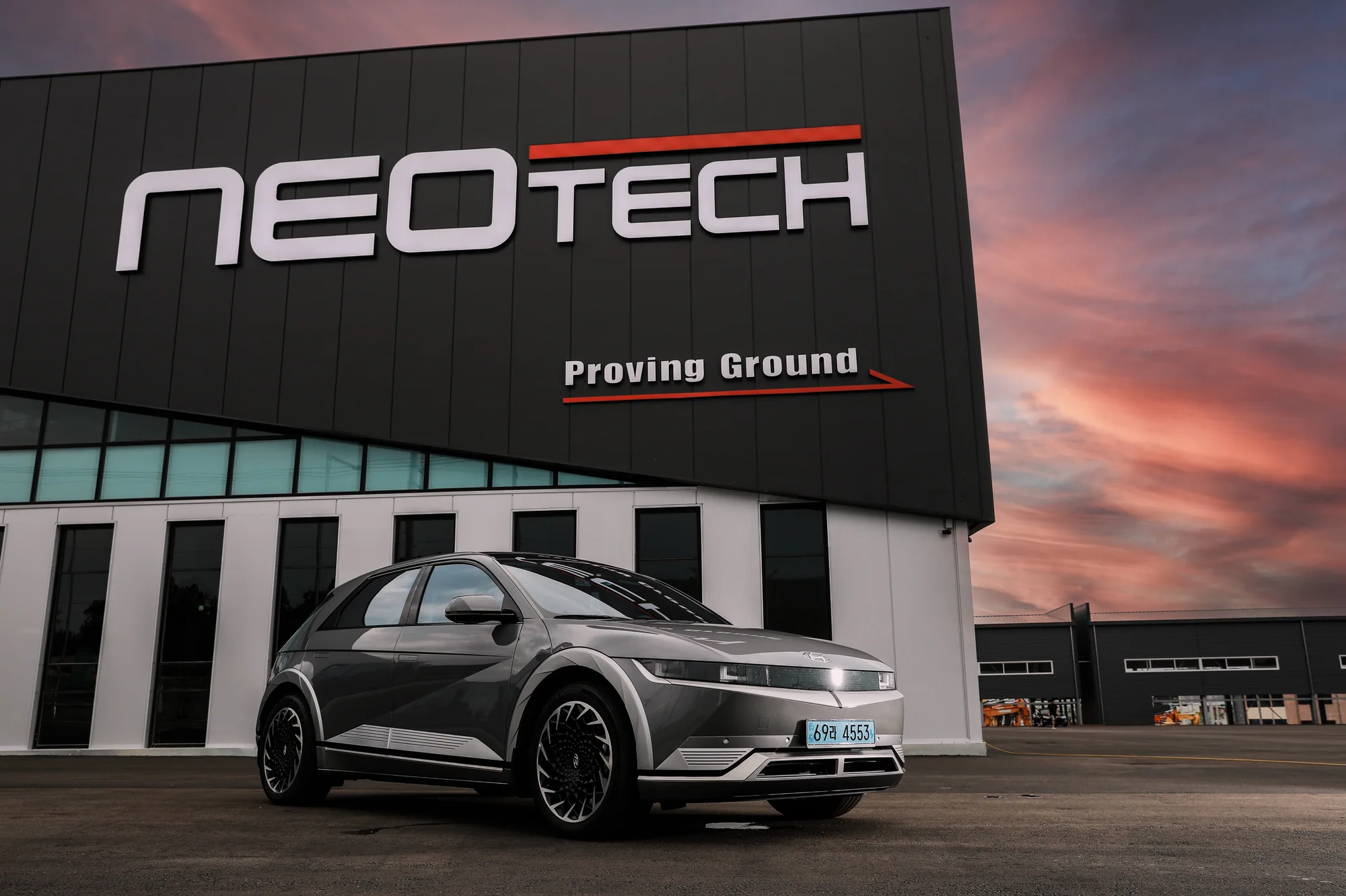 Hyundai IONIQ 5 parked in front of the Neotech proving ground in Gimcheon at sunset